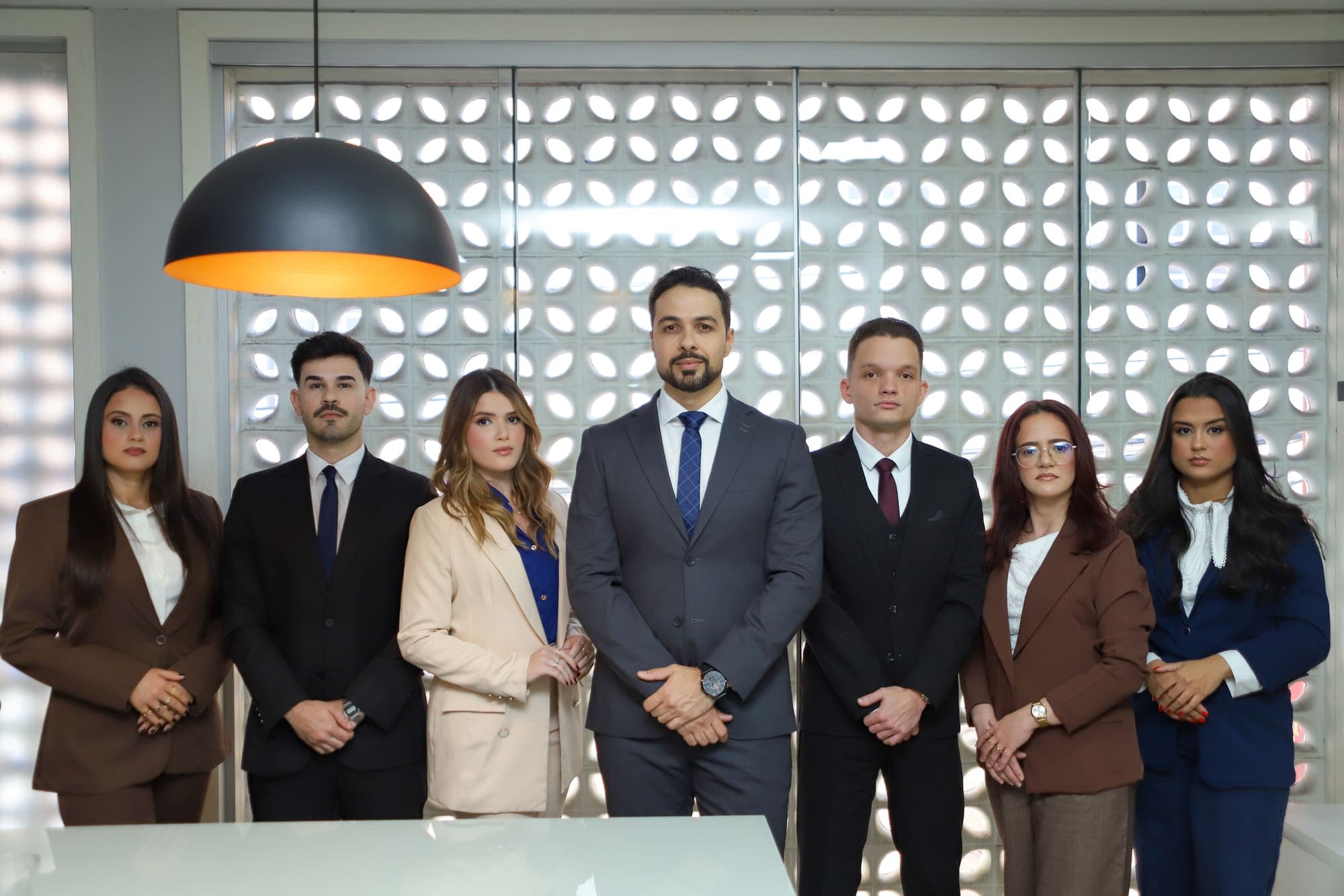 A equipe do escritório reunida em pé na sala de reuniões
